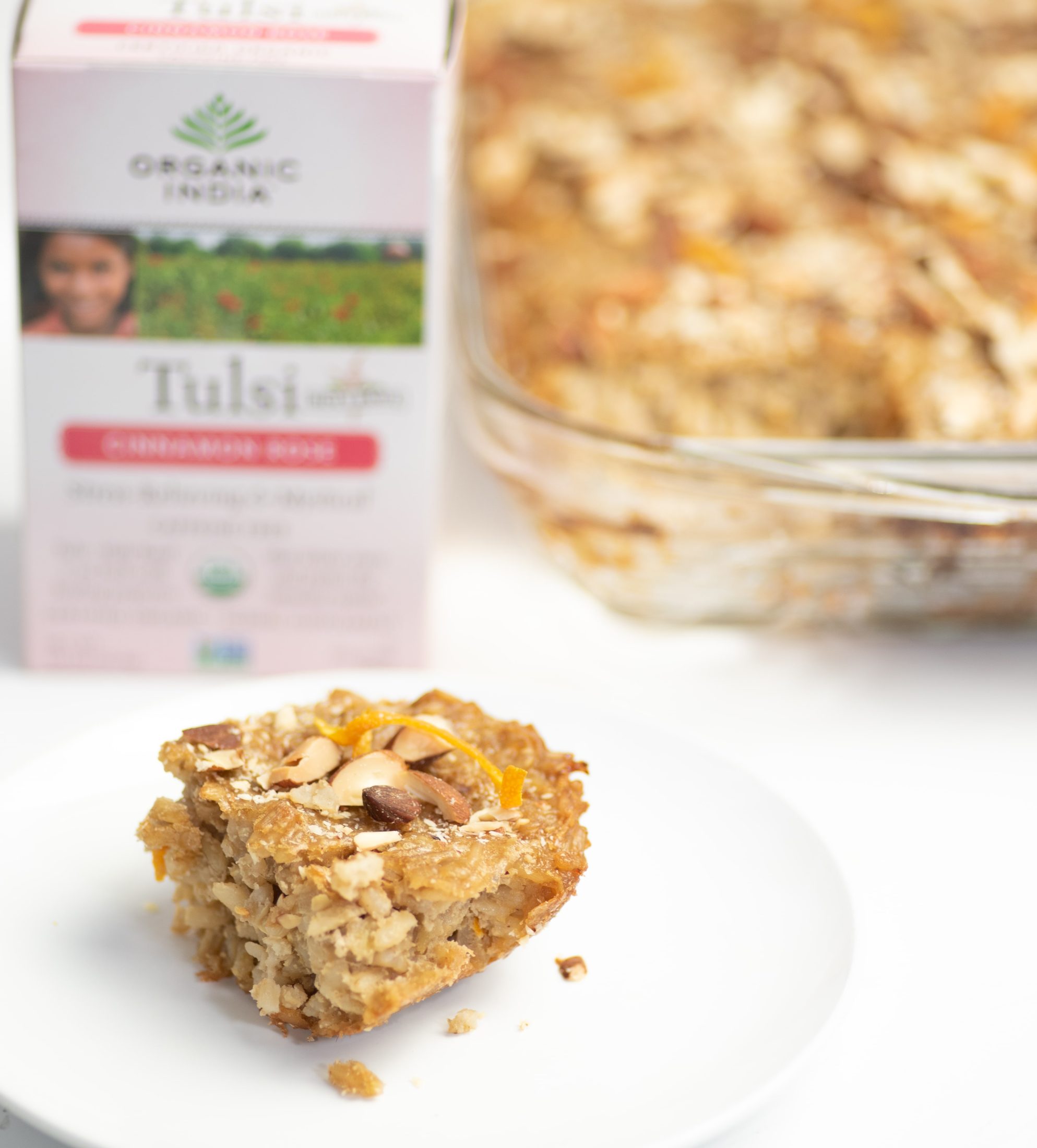 Cinnamon brown rice kugel on white plate with almond garnish.