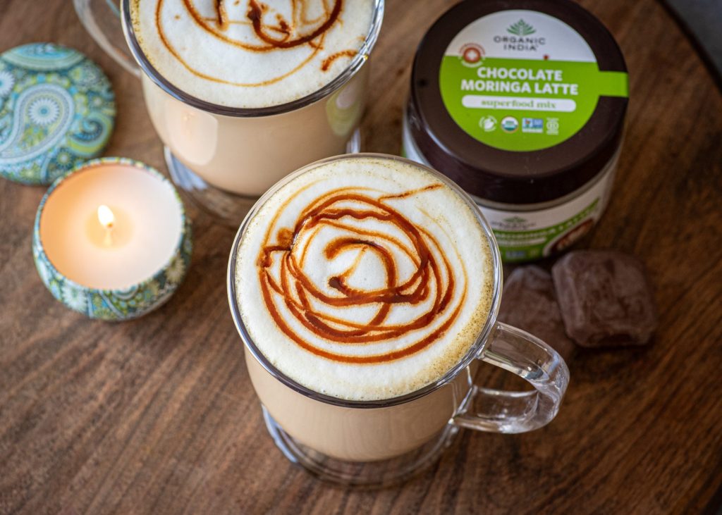 Moringa chocolate latte prepared hot in a clear mug with chocolate drizzle