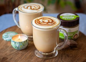 Hot moringa chocolate latte in a clear mug with chocolate drizzle