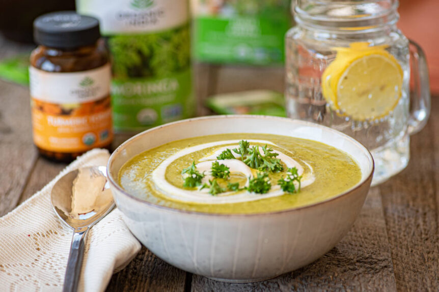 Broccoli soup green tea to balance appetite in a white ceramic bowl with fresh herb and yogurt garnish.
