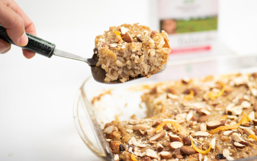 Brown rice bugel with cinnamon, almonds and raisins being freshly cut from the baking tin.