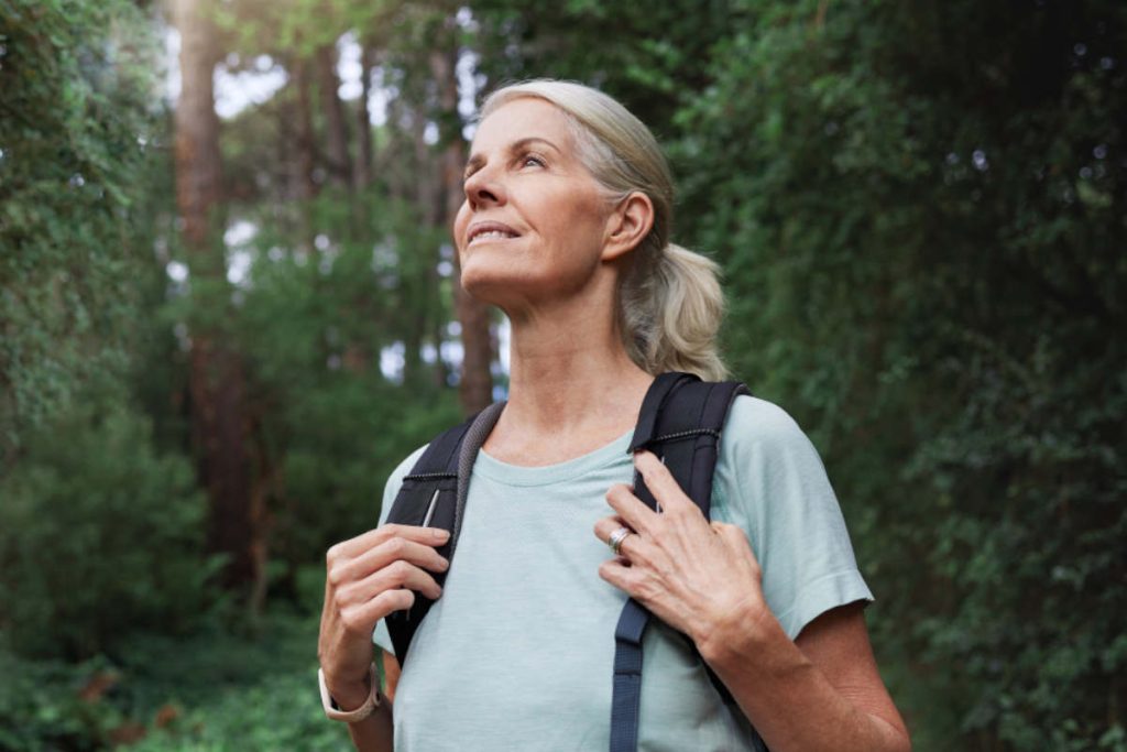 Woman with grey hair in nature for a hike