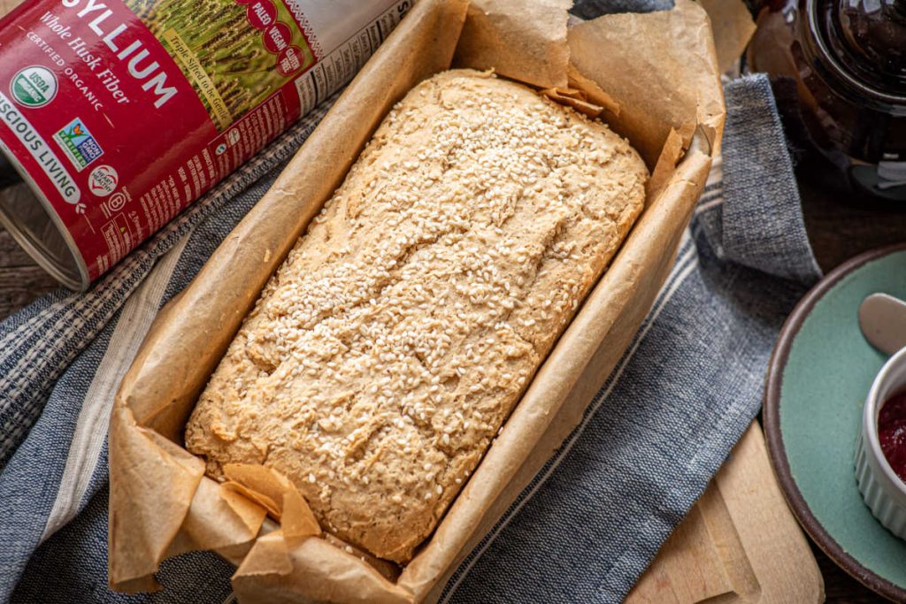 Gluten-free bread loaf fresh out the oven with psyllium whole husk and sesame seeds on top.