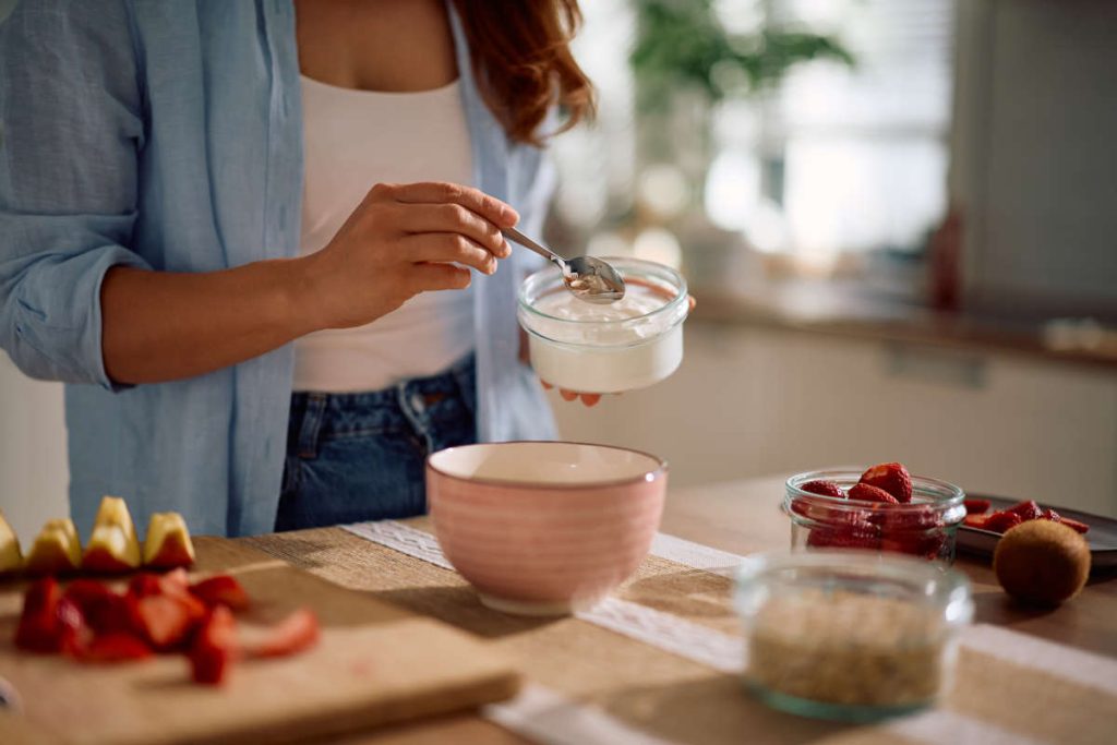 Woman preparing yogurt for digestive wellness