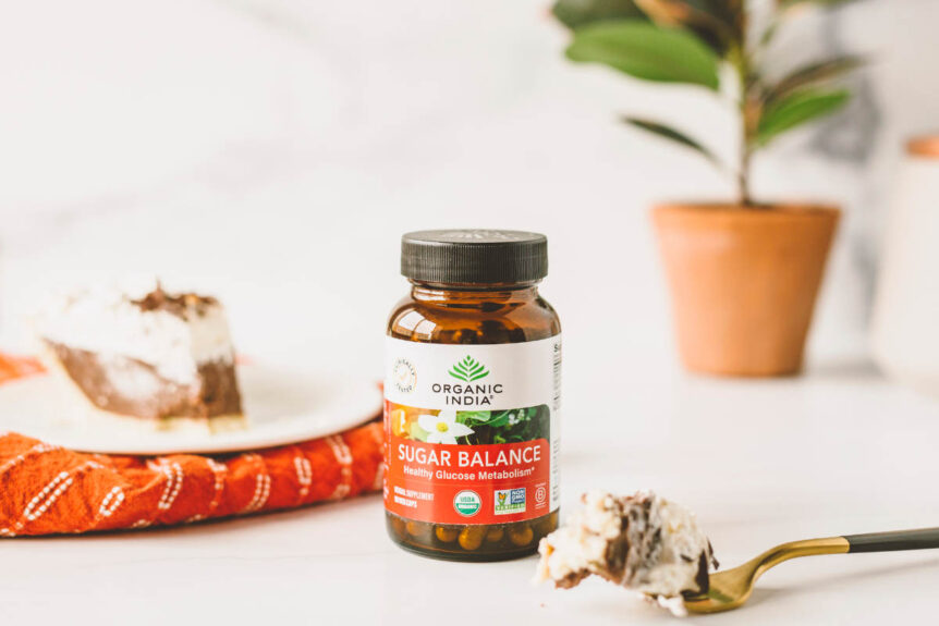 Herbs for sugar balance supplement jar with forkful of cake on table.