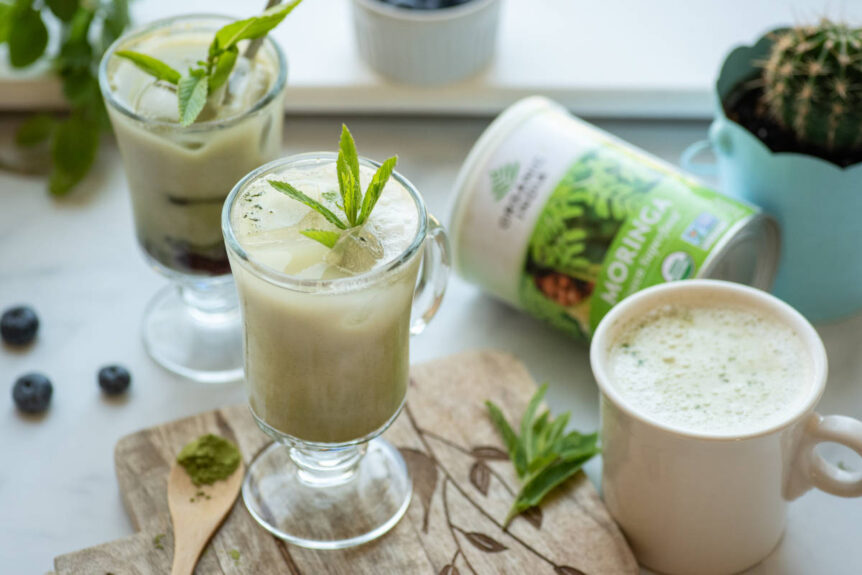 Iced matcha moringa latte iced and hot with blueberry and mint garnish.