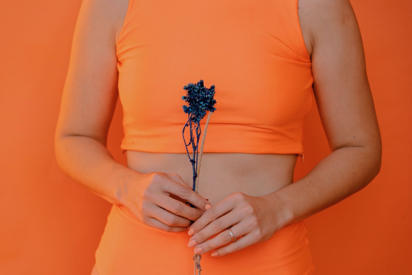Woman in orange outfit seeking gut health and healthy inflammatory response.