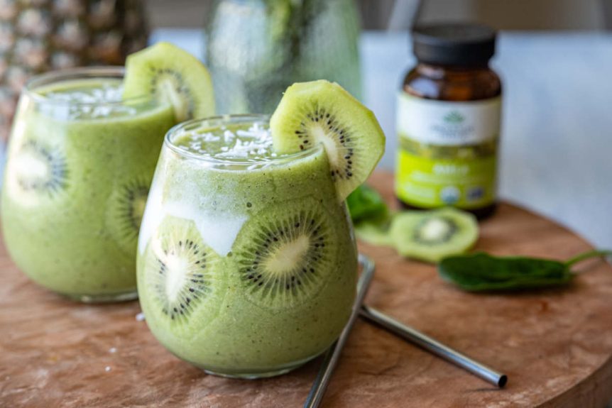 Kiwi Amla Smoothie in clear glass with fresh kiwi garnish