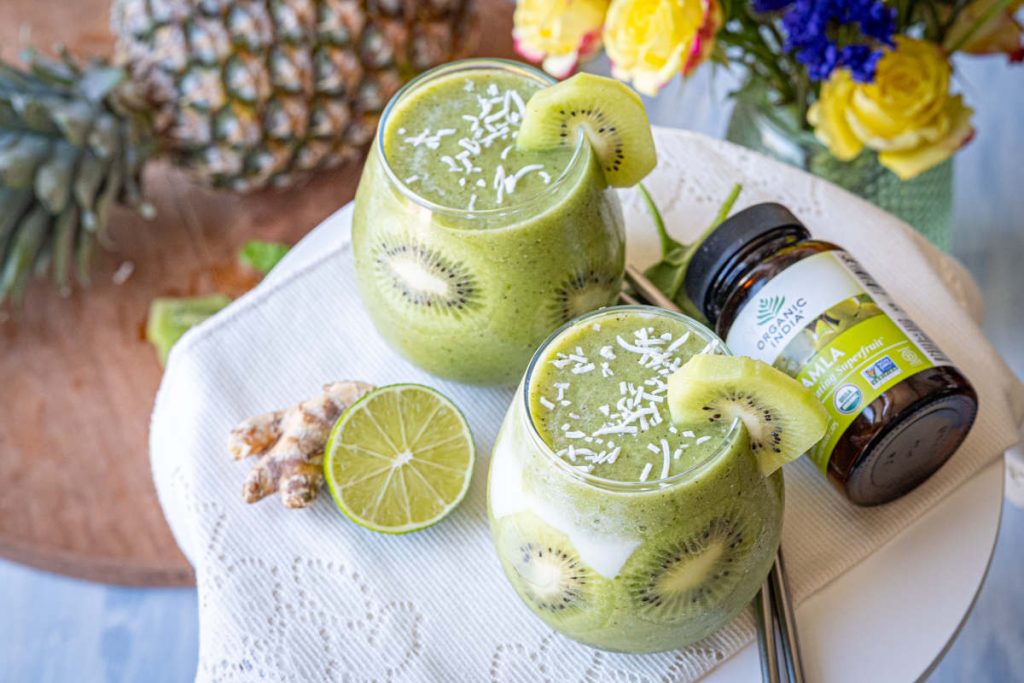 Kiwi Amla Smoothie in clear glass with fresh kiwi garnish