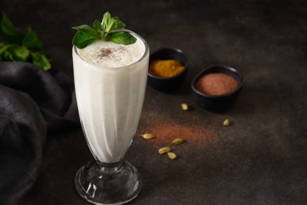Classic salty lassi in a tall glass with mint garnish