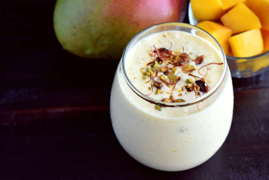 Mango lassi with garnish in a clear glass, perfect drink for summer rituals