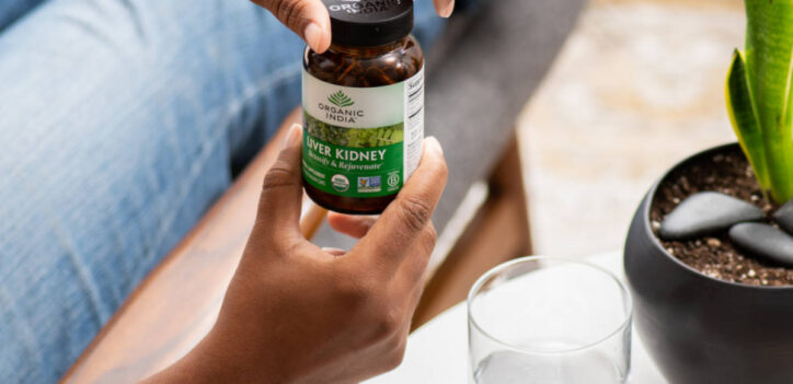 Woman with Liver Kidney glass capsule jar in her hands.