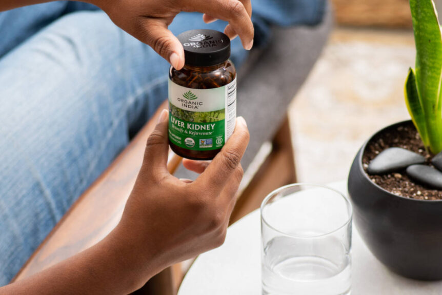 Woman taking Liver Kidney supplement, containing the best herbs for kidney health.