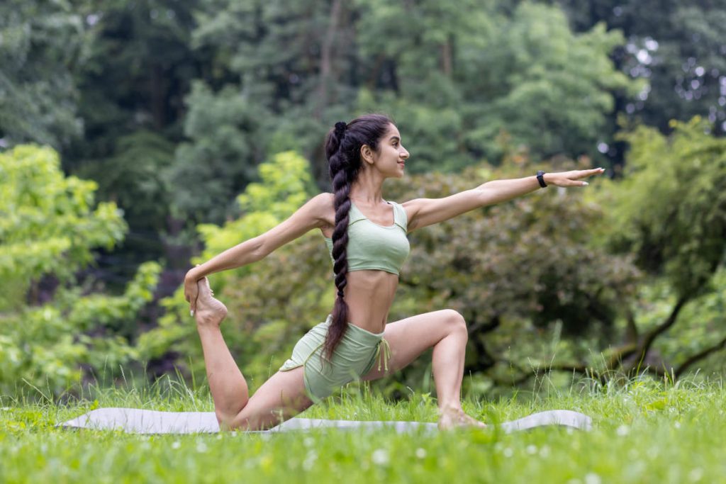 Woman practicing yoga asana out in nature