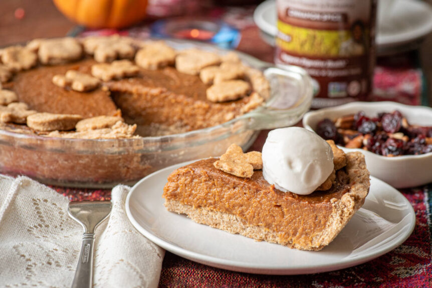 Slice of sweet potato pie with cinnamon psyllium on white plate with scoop of vegan ice cream.