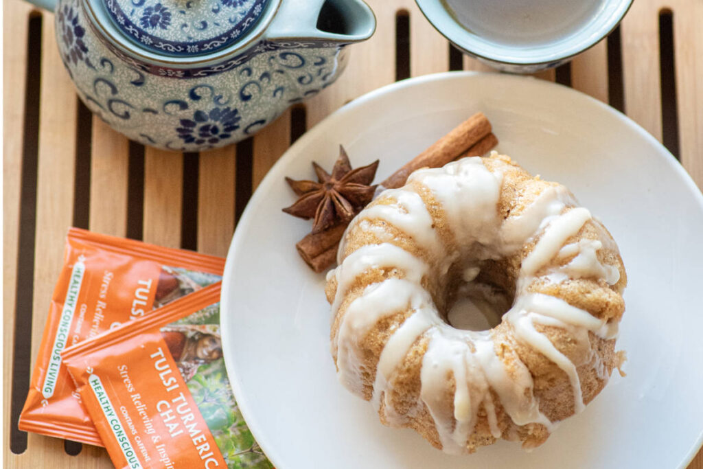 Tulsi chai tea cakes on white plate with cinnamon and clove garnish and blue asian-inspired teapot.