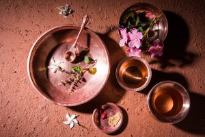 Tulsi in ayurveda plant and flowers in copper bowl