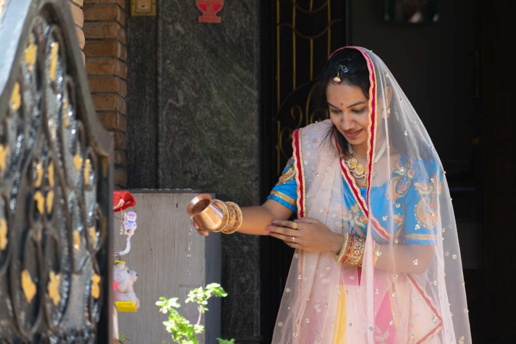 Woman tending to her tulsi plant in India