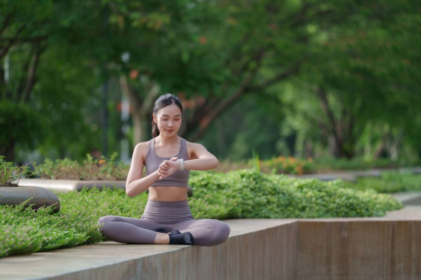 Woman practicing biohacking in nature with smart watch