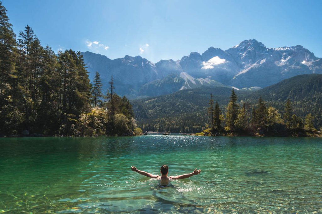 person submerging in a mountain lake