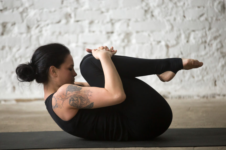 One of the top 5 stress-relieving yoga asanas is hugging knees into your chest.
